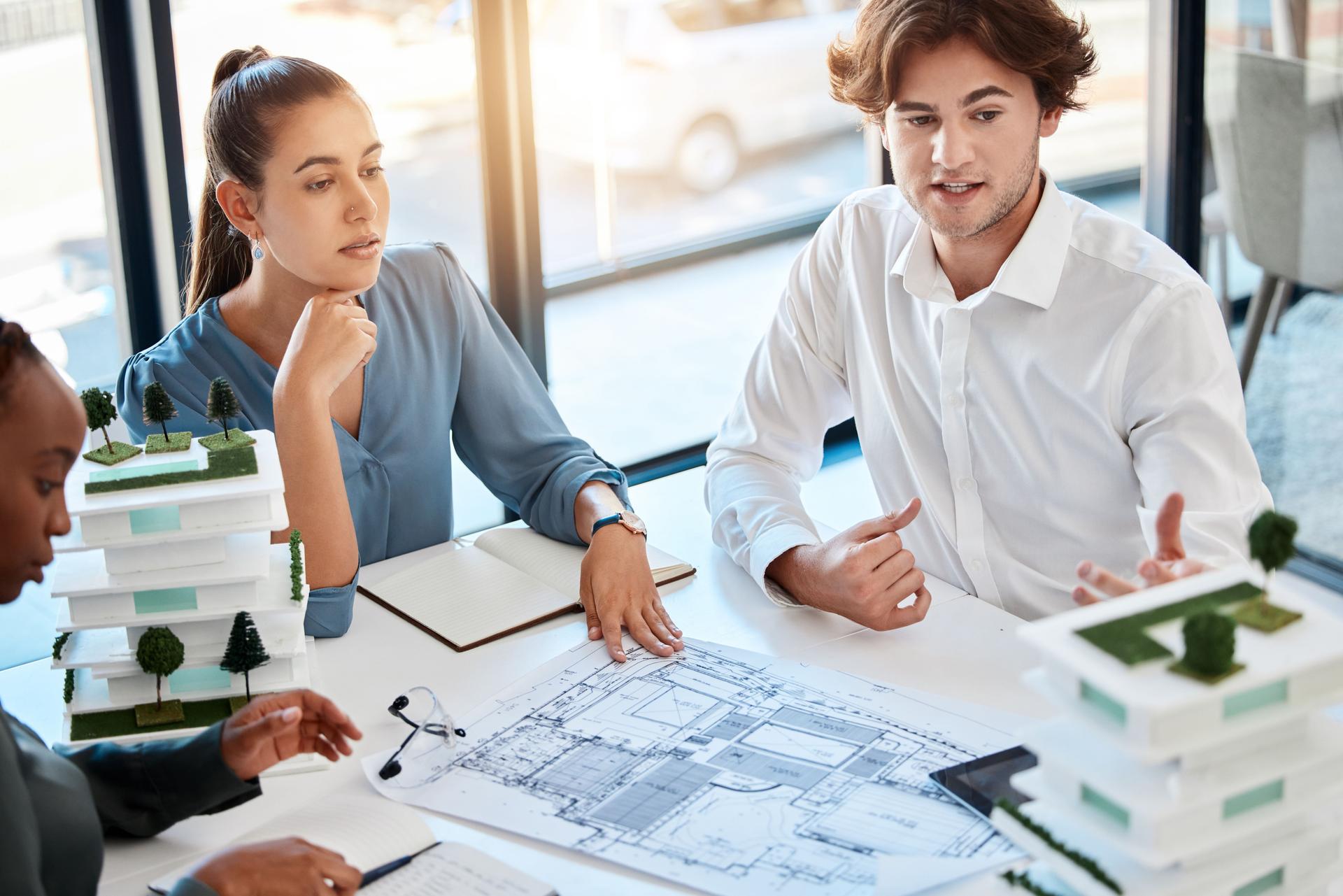 Team, architect engineer and planning building 3d model in meeting with logistics, diversity and teamwork for real estate. Business people working with architecture, construction and house design.
